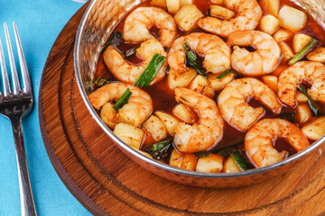 Seafood, Mediterranean cuisine, European dish. Warm salad of grilled fish pieces, shrimps and mussels in a frying pan, with grilled vegetables - with green onions, greens, mushrooms and vegetables.