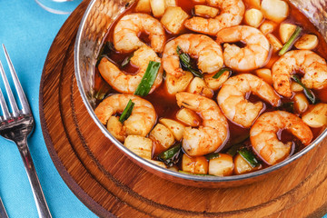 Seafood, Mediterranean cuisine, European dish. Warm salad of grilled fish pieces, shrimps and mussels in a frying pan, with grilled vegetables - with green onions, greens, mushrooms and vegetables.