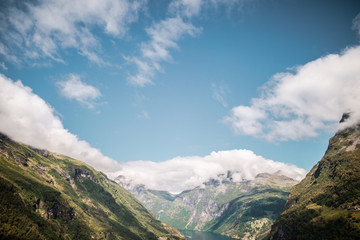 view of mountains with clouds in geiranger