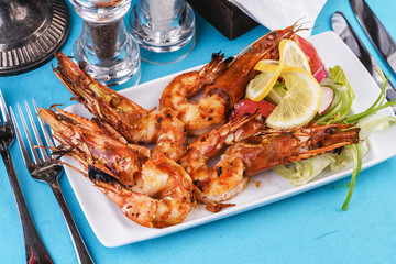 European cuisine, Mediterranean dish. Plate with assorted sea grill for beer. Fried king prawns with lemon, mussels with oyster sauce, Colmar rings, crab meat