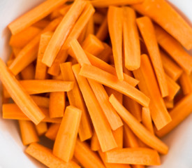 Close up of Carrot sticks in a white bowl - healthy root vegetable