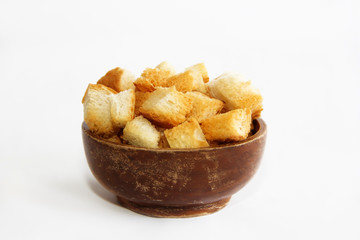 fried dry white bread crackers in a wooden plate on a white background