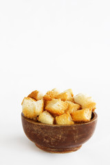 fried dry white bread crackers in a wooden plate on a white background