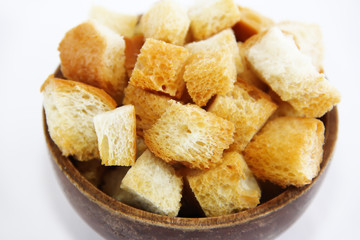 fried dry white bread crackers in a wooden plate on a white background