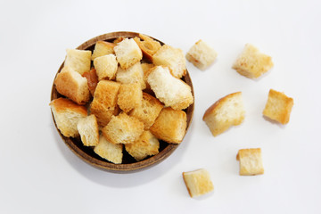 fried dry white bread crackers in a wooden plate on a white background