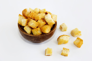 fried dry white bread crackers in a wooden plate on a white background