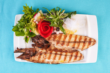 Seafood, Mediterranean cuisine. Grilled Seafood Steak fish with greens, cucumber, lemon and chili. Japanese food