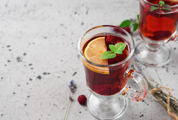 Hot fruit raspberry tea with herbs and lavender in a glass Cup