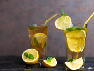 Summer cold homemade Mojito tea with mint and lemon and ice .