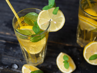 Summer cold homemade Mojito tea with mint and lemon and ice .