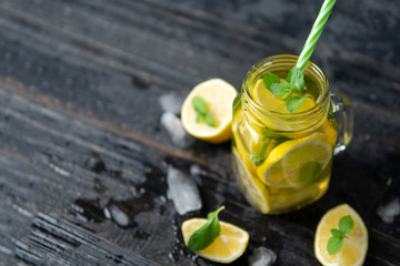 Summer cold homemade Mojito tea with mint and lemon and ice .