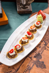 plate of corn chips nachos with fried minced meat and cream sauce on old map background
