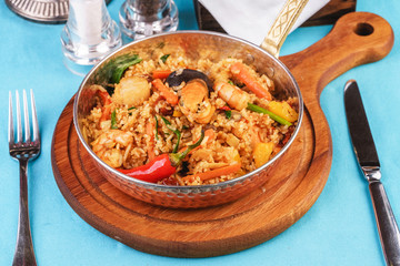 Mediterranean dish, European cuisine. The dish is from Uzbek cuisine. Rice fried with vegetables - greens, carrots, red pepper, onions and seafood - shrimps, mussels and squid.