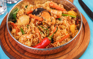 Mediterranean dish, European cuisine. The dish is from Uzbek cuisine. Rice fried with vegetables - greens, carrots, red pepper, onions and seafood - shrimps, mussels and squid.