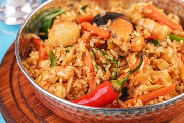 Mediterranean dish, European cuisine. The dish is from Uzbek cuisine. Rice fried with vegetables - greens, carrots, red pepper, onions and seafood - shrimps, mussels and squid.