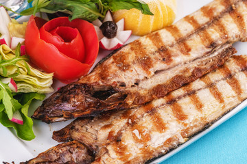 Seafood, Mediterranean cuisine. Grilled Seafood Steak fish with greens, cucumber, lemon and chili. Japanese food