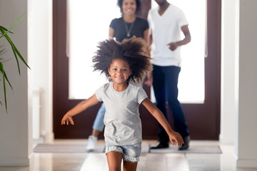 Happy african family with little daughter arrived at new house