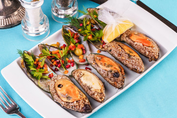 European cuisine, Mediterranean dish. Plate of assorted mussels and oysters cooked with spices i berries