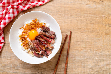 sliced beef on topped rice bowl with egg