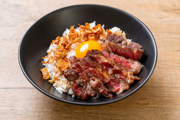 sliced beef on topped rice bowl with egg