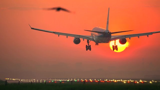 Airplane crossing the sun at sunrise
