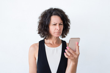 Stressed woman with smartphone suffering from weak eyesight. Middle aged woman with partly closed eyes staring at cellphone screen and trying to read. Weak sight concept