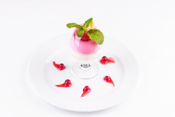 European dessert, national cuisine. Cream mousse under pink jelly, served with lingonberries, banana and strawberries in a glass