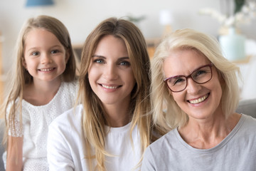 Daughter granddaughter and grandmother looking at camera