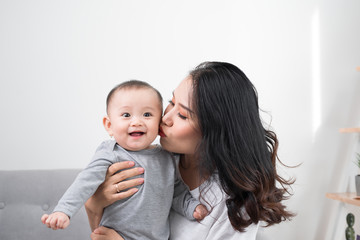 happy family at home. Mother holding baby daughter in living room in cozy weekend morning