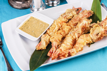 European cuisine, Mediterranean dish. Whole prawns fried in butter and batter snack for beer with cream-mustard sauce