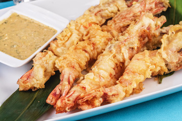 European cuisine, Mediterranean dish. Whole prawns fried in butter and batter snack for beer with cream-mustard sauce