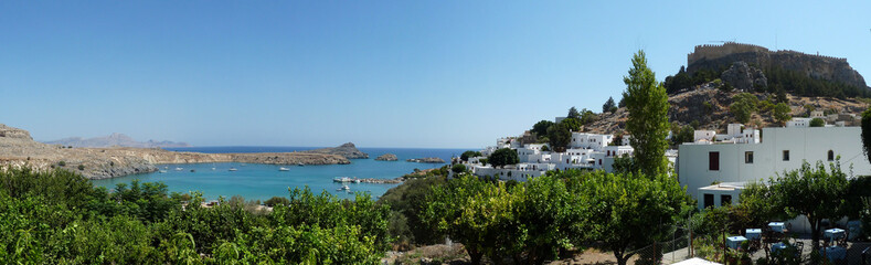 Panoramic view of Lindos beach, Acropolis & tomb of Kleoboulos, Rhodes Island, Greece