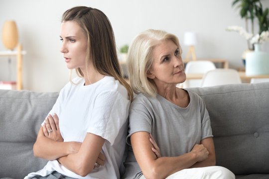 Mother and daughter sitting on couch after quarrel