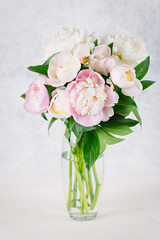 Bouquet of peonies in a vase closeup on pastel background