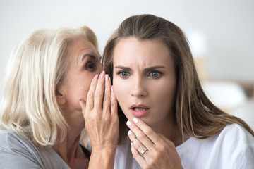 Close up portrait of mother and daughter whispering