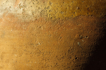 A fragment of an old clay pot. The surface of the ceramic product. Texture. Close-up. The small depth of field