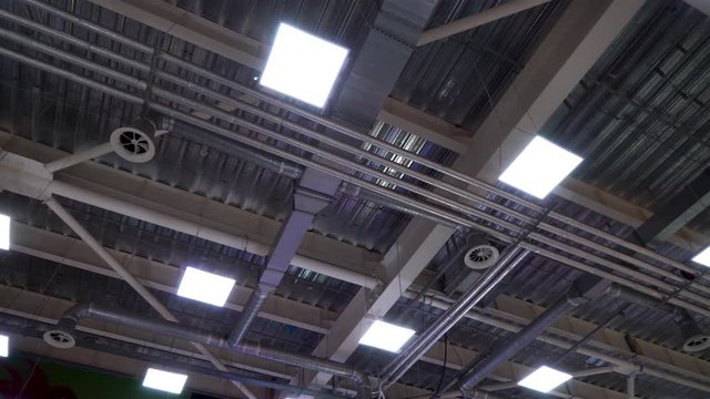 ceiling of big industrial building with air duct ventilation pipes