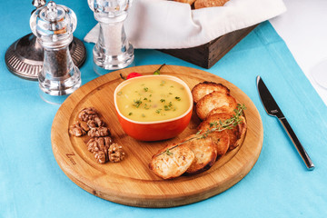 Mediterranean dish, European cuisine. Fish and cream cheese soup with herbs, garlic bread, red and green chili peppers, thyme and walnuts