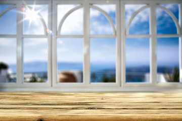 Table background with beautiful blue ocean and sandy beach view behind the window. Summer sunny day. Empty space for your decoration and advertising product.