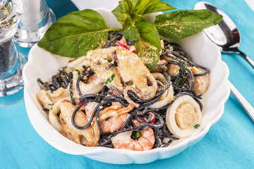 Seafood, Mediterranean cuisine. Black paste with squid ink, with squid meat, crab, shrimp and fish. Caucasian kitchen
