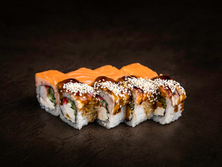 Mini-set of two types of rolls in the Japanese style on a dark background side view