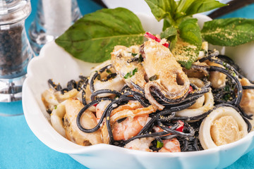 Seafood, Mediterranean cuisine. Black paste with squid ink, with squid meat, crab, shrimp and fish. Caucasian kitchen