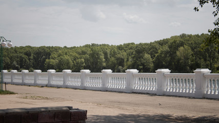 Embankment of river. City summer landscape. White parapet.