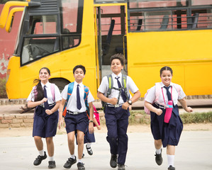 Schoolboys and schoolgirls walking of the school bus