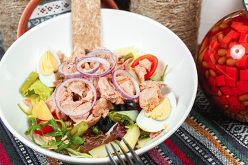 Fish salad of tuna, vegetables, tomatoes, peppers, onion rings, eggs, cabbage, lettuce and asparagus in the Georgian style. National cuisine