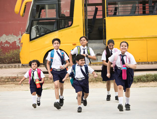 Schoolboys and schoolgirls walking of the school bus