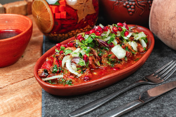 goulash from beef, veal and vegetables - tomato, cabbage, potatoes, served with greens and pomegranate seeds, Georgian appetizer. National cuisine