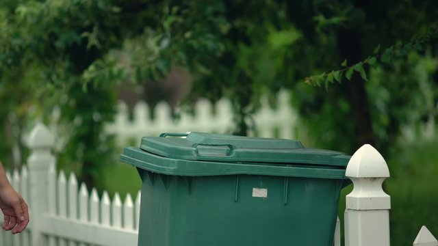 Male citizen throwing garbage in trash can, preventing littering, environment