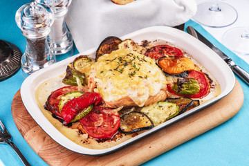 Mediterranean dish, Georgian recipe. Baked chicken steak with lemon, vegetables, pepper, zucchini, eggplants and grilled tomatoes with spices