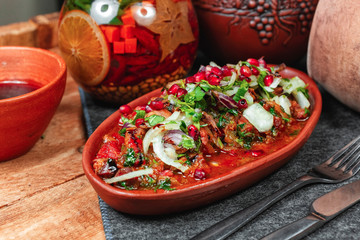 goulash from beef, veal and vegetables - tomato, cabbage, potatoes, served with greens and pomegranate seeds, Georgian appetizer. National cuisine